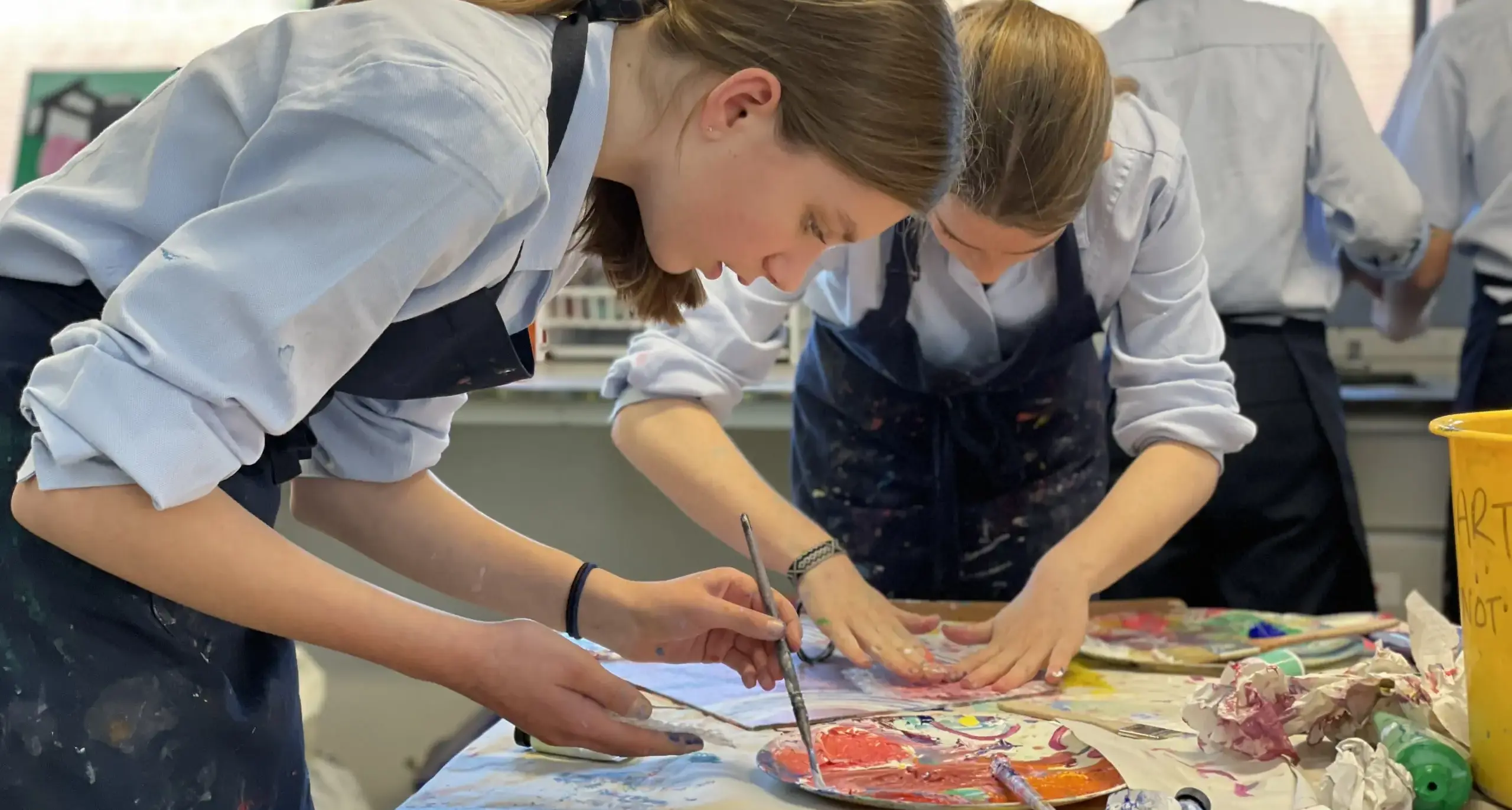 Students in aprons working on art